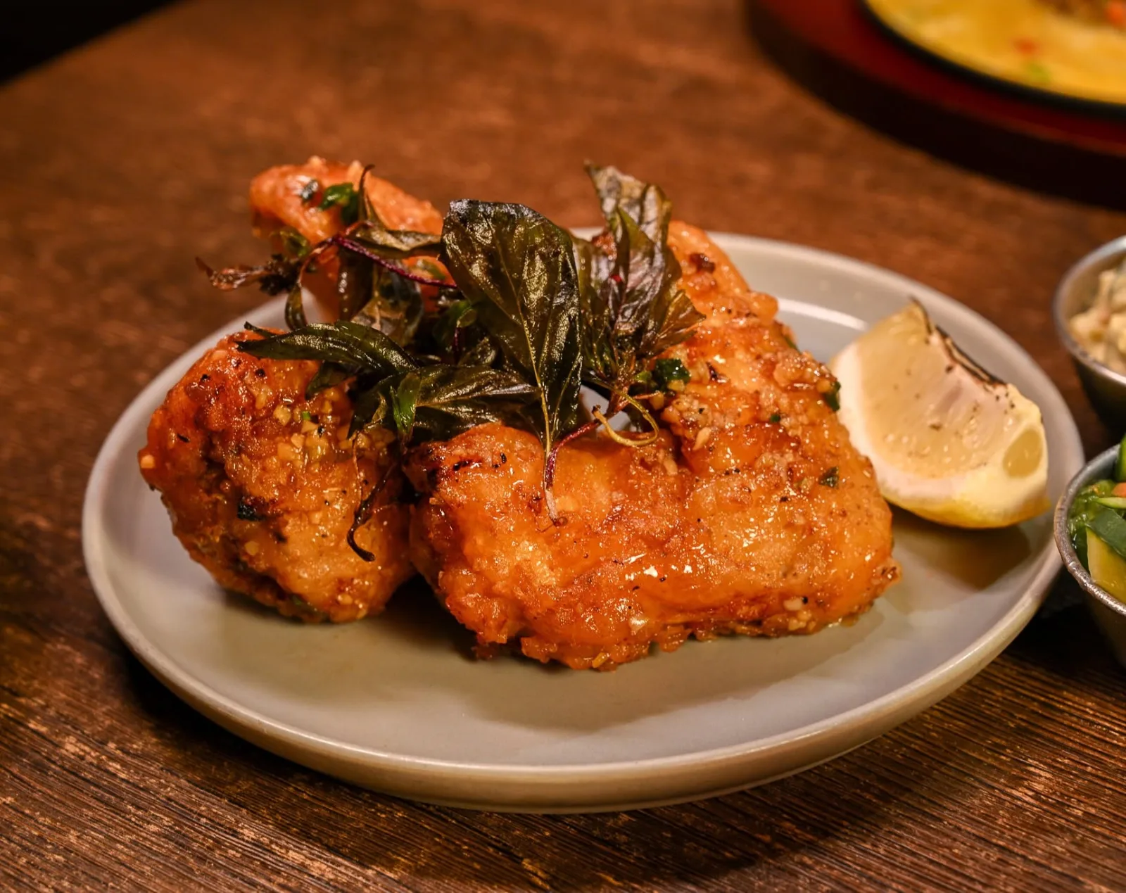 Crispy Japanese fried chicken with fried herbs and lemon