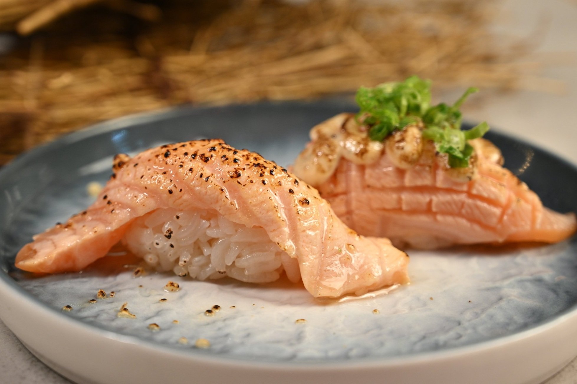 Torched salmon nigiri pair at the bar